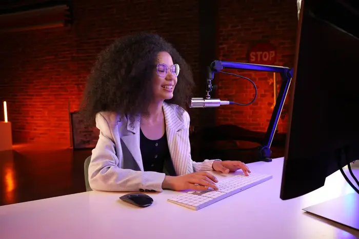 A woman is at her desk, working on a computer, illustrating a scene of concentration and productivity.
